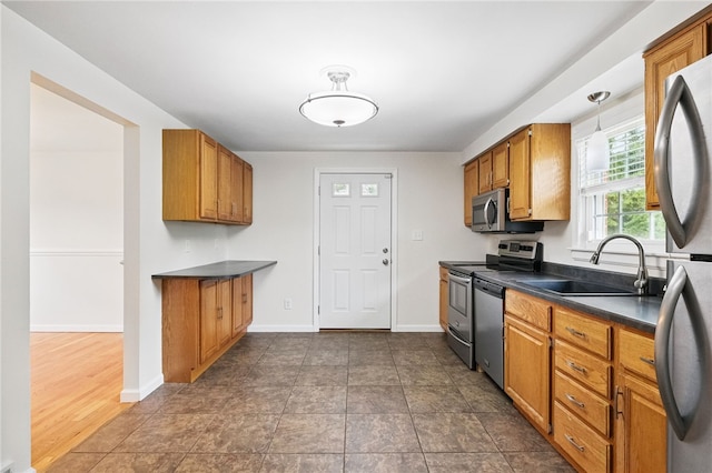 7965 Remington Dr, Mccandless, PA 15237 - kitchen featuring stainless steel appliances, a sink, dark countertops, and brown cabinets