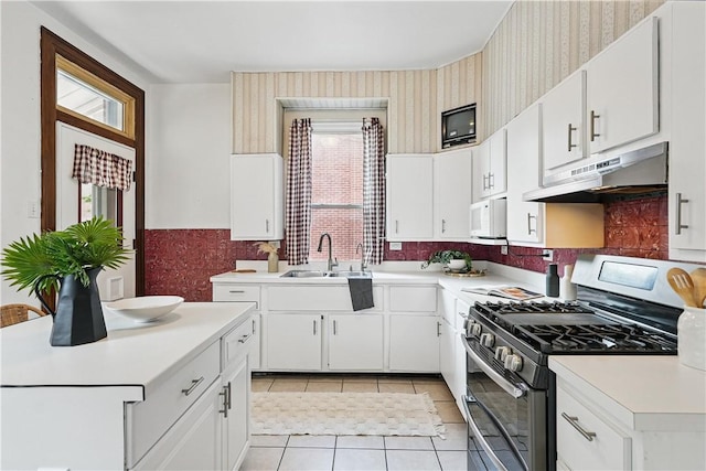 5150 Friendship Ave, Friendship Park, PA 15224 - kitchen with stainless steel gas range, a sink, wallpapered walls, white microwave, and under cabinet range hood