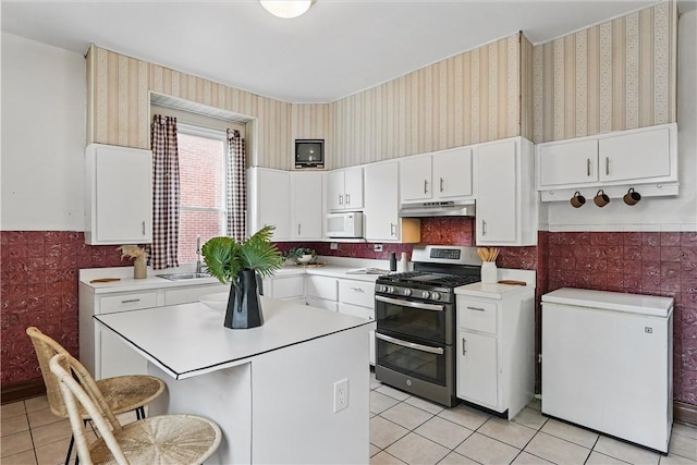 5150 Friendship Ave, Friendship Park, PA 15224 - kitchen featuring range with two ovens, wallpapered walls, white microwave, light tile patterned flooring, and wainscoting