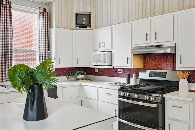 5150 Friendship Ave, Friendship Park, PA 15224 - kitchen with range with two ovens, white microwave, wallpapered walls, under cabinet range hood, and light countertops