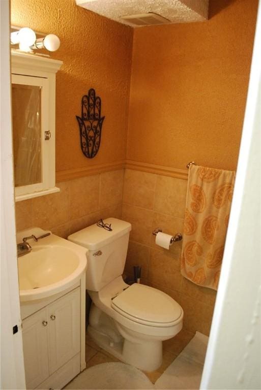5120 5th Ave Unit 103, Shadyside, PA 15232 - half bath featuring vanity, toilet, tile walls, and tile patterned floors