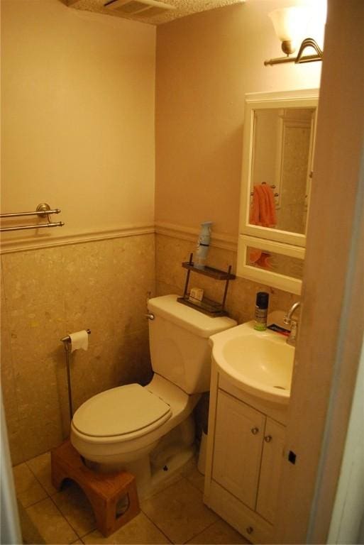 5120 5th Ave Unit 103, Shadyside, PA 15232 - bathroom featuring vanity, toilet, tile patterned flooring, and wainscoting