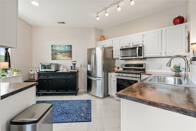 832 Eagle Pointe Dr, Cecil, PA 15317 - kitchen with appliances with stainless steel finishes, a sink, dark countertops, white cabinetry, and backsplash