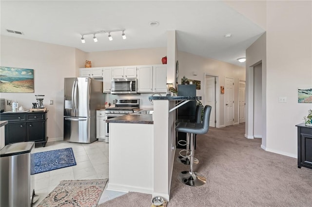 832 Eagle Pointe Dr, Cecil, PA 15317 - kitchen with stainless steel appliances, dark countertops, white cabinets, a kitchen bar, and a peninsula