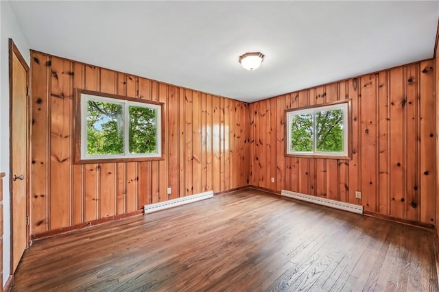 19 Ruth St, Hempfield Twp Mer, PA 16125 - unfurnished room featuring a baseboard heating unit, wood-type flooring, plenty of natural light, and wooden walls