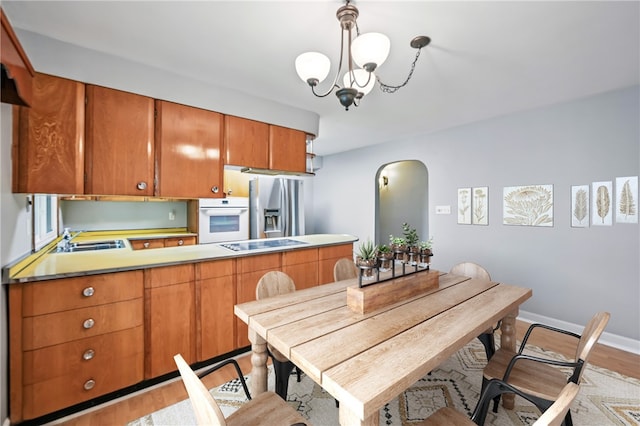 19 Ruth St, Hempfield Twp Mer, PA 16125 - kitchen with white oven, stainless steel fridge with ice dispenser, a chandelier, black electric stovetop, and arched walkways