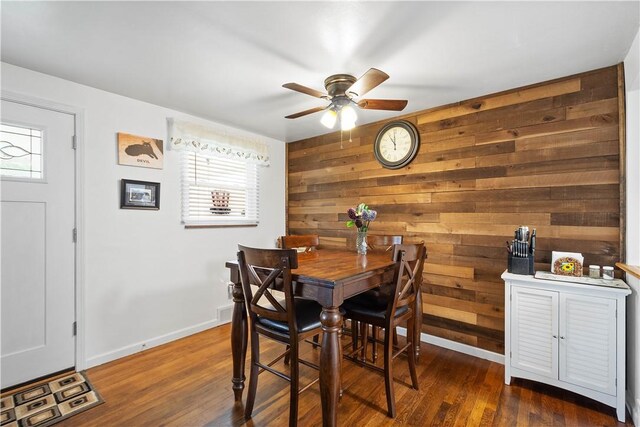 260 Bluemont Dr, West Mifflin, PA 15122 - dining area featuring wooden walls, a ceiling fan, plenty of natural light, and dark wood-type flooring