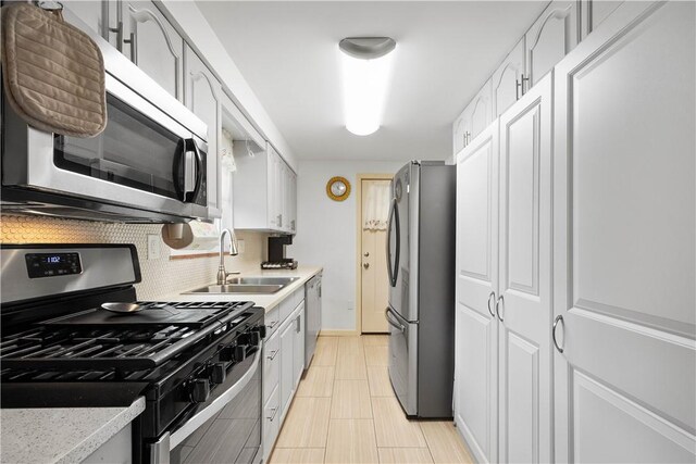 260 Bluemont Dr, West Mifflin, PA 15122 - kitchen featuring appliances with stainless steel finishes, a sink, light countertops, tasteful backsplash, and white cabinetry