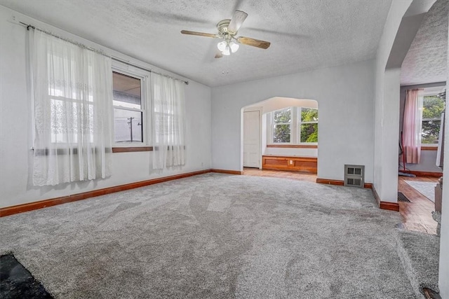1675 Clairton Rd, West Mifflin, PA 15122 - unfurnished living room with carpet floors, healthy amount of natural light, a ceiling fan, and a textured ceiling