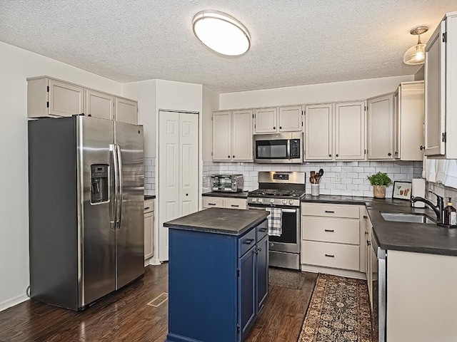 104 Rylie Dr, Jackson Twp But, PA 16037 - kitchen featuring appliances with stainless steel finishes, a sink, dark countertops, a kitchen island, and dark wood-style flooring