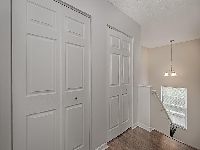 104 Rylie Dr, Jackson Twp But, PA 16037 - hallway with an upstairs landing, dark wood-style floors, a chandelier, baseboards, and a textured ceiling
