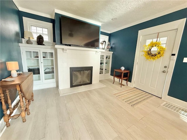 410 E Meyer Ave, New Castle/2Nd, PA 16105 - entrance foyer with wood finished floors, a tile fireplace, crown molding, a textured ceiling, and baseboards