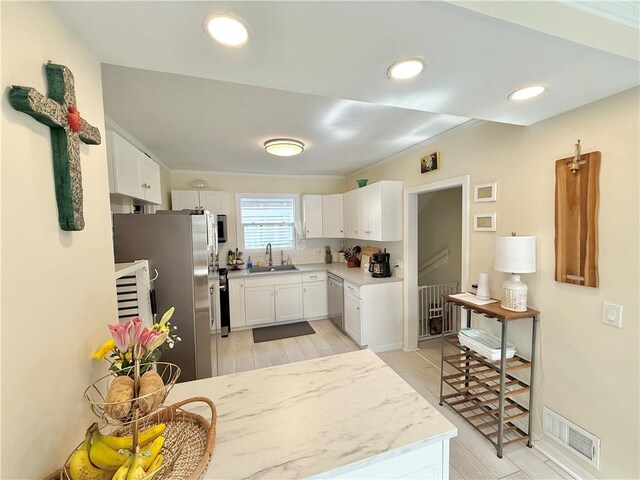 410 E Meyer Ave, New Castle/2Nd, PA 16105 - kitchen with a sink, appliances with stainless steel finishes, white cabinetry, recessed lighting, and tasteful backsplash