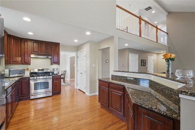 1148 Camarta Dr, Baldwin Boro, PA 15227 - kitchen featuring appliances with stainless steel finishes, light wood-style flooring, under cabinet range hood, dark stone countertops, and recessed lighting