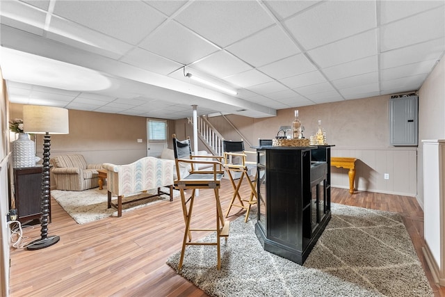 444 Tivoli Rd, Plum Boro, PA 15239 - bar featuring a drop ceiling, wood finished floors, electric panel, stairs, and a wainscoted wall