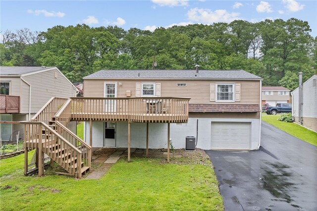 444 Tivoli Rd, Plum Boro, PA 15239 - rear view of property with a wooden deck, an attached garage, asphalt driveway, and a lawn