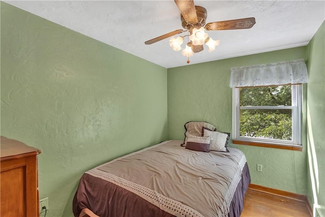 320 Pinevue Dr, Monroeville, PA 15146 - bedroom with wood finished floors, a textured wall, baseboards, and a ceiling fan