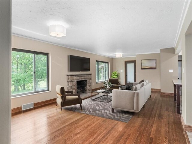330 Center Grange Rd, Center Twp Bea, PA 15061 - living room with a stone fireplace, wood finished floors, ornamental molding, baseboards, and a textured ceiling