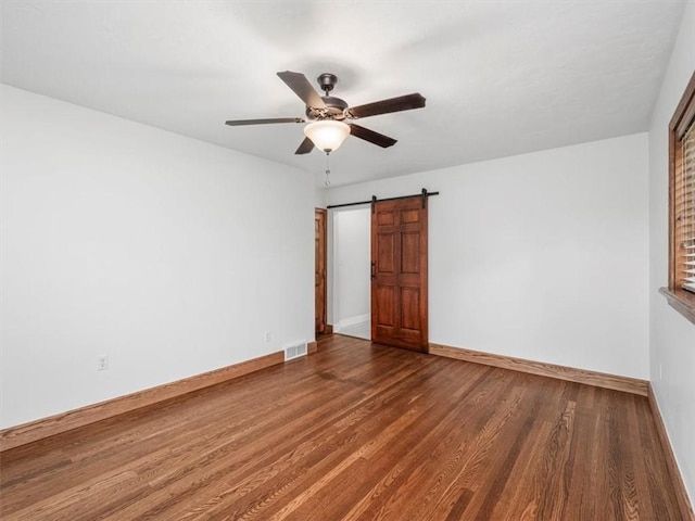 330 Center Grange Rd, Center Twp Bea, PA 15061 - unfurnished room featuring a barn door, ceiling fan, wood finished floors, and baseboards