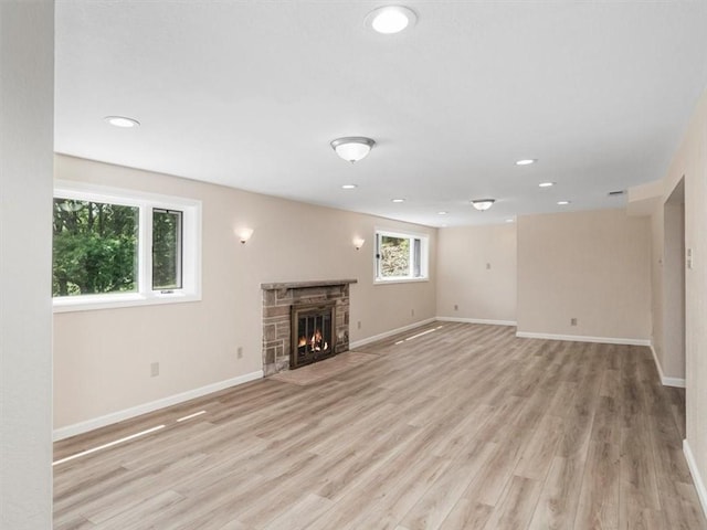 330 Center Grange Rd, Center Twp Bea, PA 15061 - unfurnished living room with baseboards, light wood-style flooring, recessed lighting, and a stone fireplace