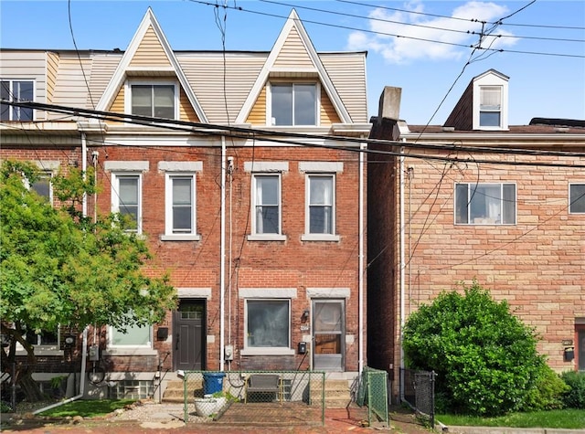 4123 Foster St, Lawrenceville, PA 15201 - view of front of property featuring brick siding, a fenced front yard, entry steps, and a gate