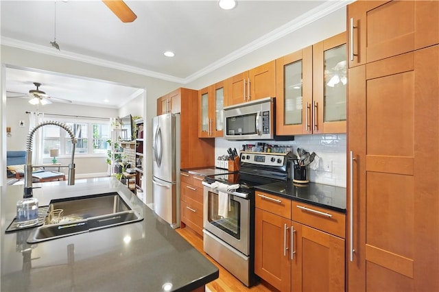 2511 Mission St, South Side, PA 15203 - kitchen with appliances with stainless steel finishes, ceiling fan, a sink, brown cabinetry, and glass insert cabinets