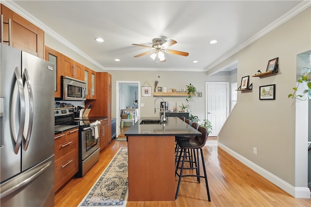 2511 Mission St, South Side, PA 15203 - kitchen with stainless steel appliances, a sink, dark countertops, brown cabinets, and a kitchen breakfast bar