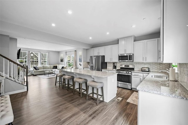 414 Greenwood Dr, North Strabane, PA 15317 - kitchen with appliances with stainless steel finishes, a sink, a center island, dark wood-style floors, and a kitchen bar