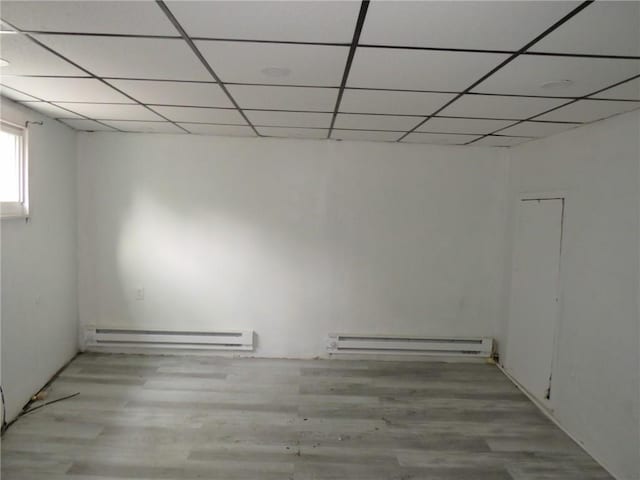 109 Parkfield St, Carrick, PA 15210 - basement featuring a baseboard heating unit, baseboard heating, a drop ceiling, and wood finished floors