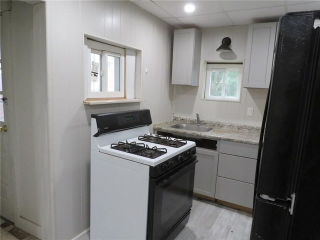 109 Parkfield St, Carrick, PA 15210 - kitchen featuring range with gas stovetop, freestanding refrigerator, a sink, light countertops, and light wood finished floors