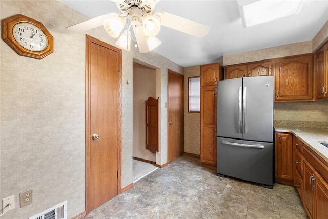 645 Dewalt Dr, Baldwin Twp, PA 15234 - kitchen with freestanding refrigerator, brown cabinetry, a ceiling fan, and light countertops