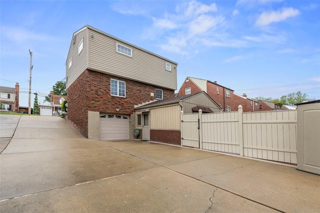 645 Dewalt Dr, Baldwin Twp, PA 15234 - view of home's exterior featuring brick siding, driveway, an attached garage, and a gate