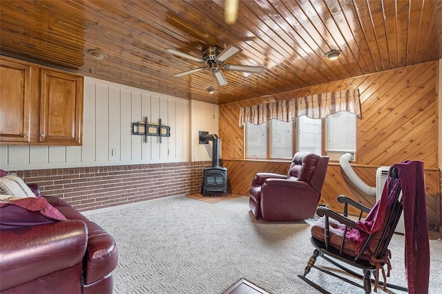 645 Dewalt Dr, Baldwin Twp, PA 15234 - living room featuring a wood stove, wooden ceiling, wooden walls, carpet, and a ceiling fan