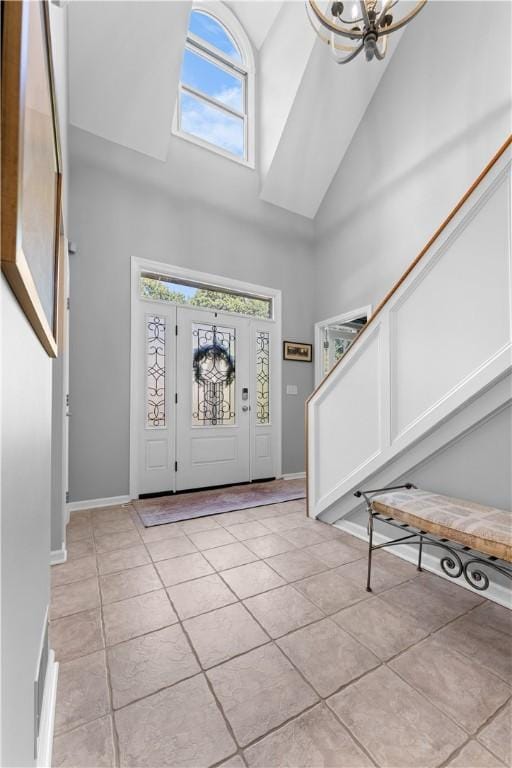 122 Hunter Dr, Cranberry Twp, PA 16066 - foyer featuring high vaulted ceiling, light tile patterned floors, a chandelier, stairs, and baseboards