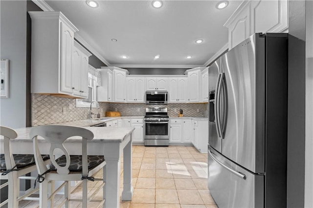 122 Hunter Dr, Cranberry Twp, PA 16066 - kitchen with appliances with stainless steel finishes, a peninsula, light countertops, white cabinetry, and decorative backsplash