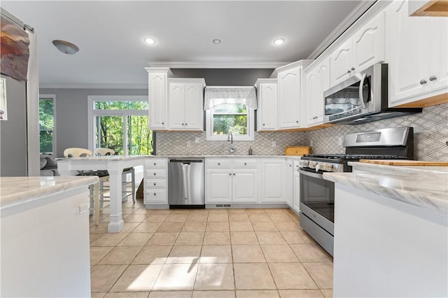 122 Hunter Dr, Cranberry Twp, PA 16066 - kitchen with stainless steel appliances, ornamental molding, decorative backsplash, a sink, and white cabinetry