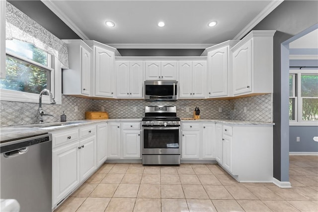 122 Hunter Dr, Cranberry Twp, PA 16066 - kitchen with appliances with stainless steel finishes, light countertops, ornamental molding, light tile patterned floors, and white cabinetry