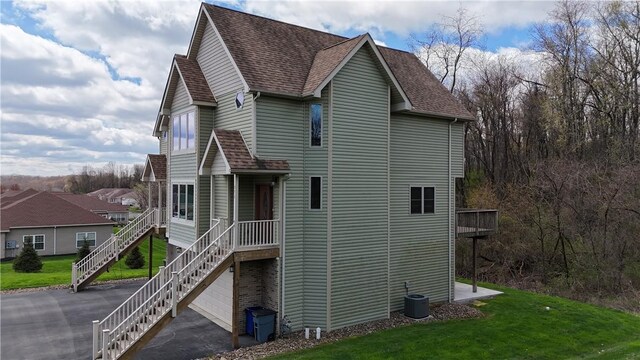 373 Cherokee Dr, Chippewa Twp, PA 15010 - view of property exterior with a shingled roof, a lawn, central air condition unit, and driveway