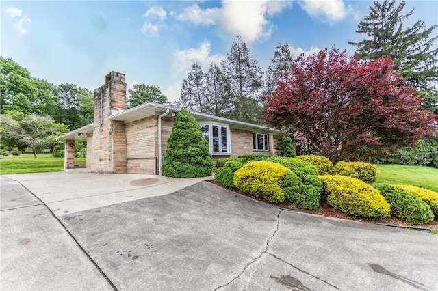240 Connellsville St, Dunbar, PA 15431 - view of home's exterior with stone siding, a chimney, driveway, and a yard