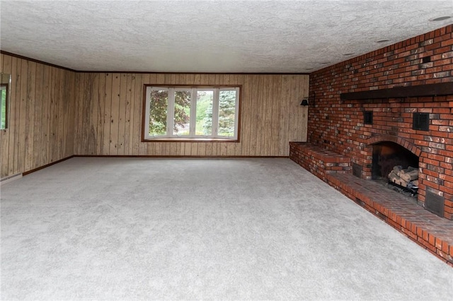 240 Connellsville St, Dunbar, PA 15431 - unfurnished living room featuring a textured ceiling, wood walls, carpet, a fireplace, and baseboards