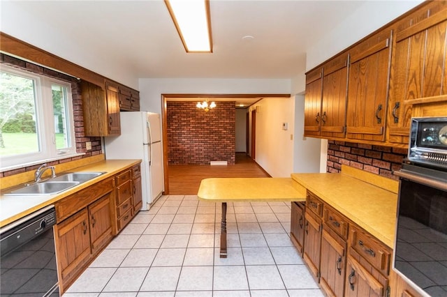 240 Connellsville St, Dunbar, PA 15431 - kitchen featuring black appliances, a sink, brick wall, light countertops, and brown cabinetry
