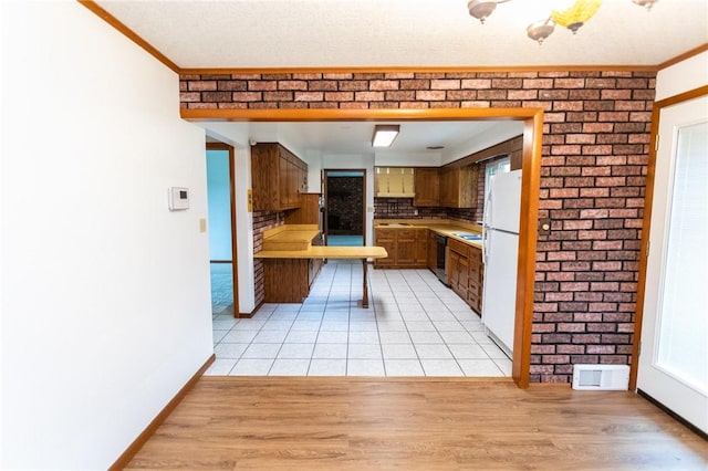 240 Connellsville St, Dunbar, PA 15431 - kitchen with freestanding refrigerator, black dishwasher, decorative backsplash, light countertops, and crown molding