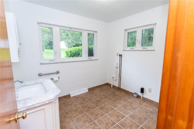 240 Connellsville St, Dunbar, PA 15431 - laundry area with plenty of natural light, a sink, light tile patterned floors, and baseboards