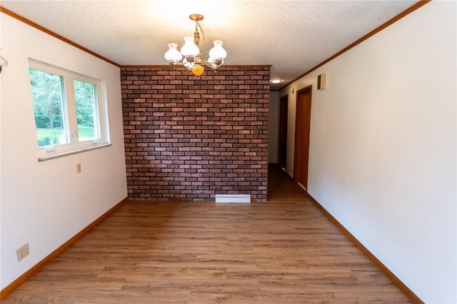 240 Connellsville St, Dunbar, PA 15431 - unfurnished dining area featuring crown molding, a chandelier, light wood finished floors, a textured ceiling, and brick wall