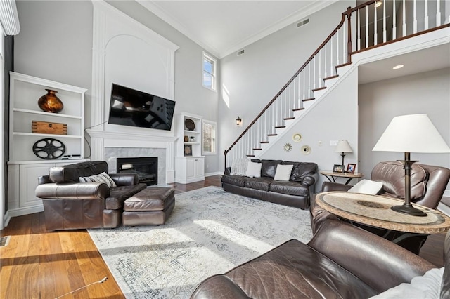 805 Saddleback Ct, Hempfield Twp Wml, PA 15601 - living room with a high ceiling, wood finished floors, stairs, a premium fireplace, and crown molding