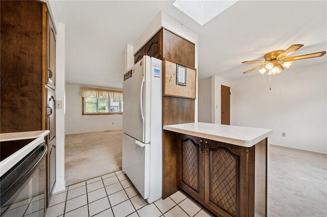 2154 Lancelot Dr, North Huntingdon, PA 15642 - kitchen with freestanding refrigerator, light carpet, a peninsula, light countertops, and a skylight