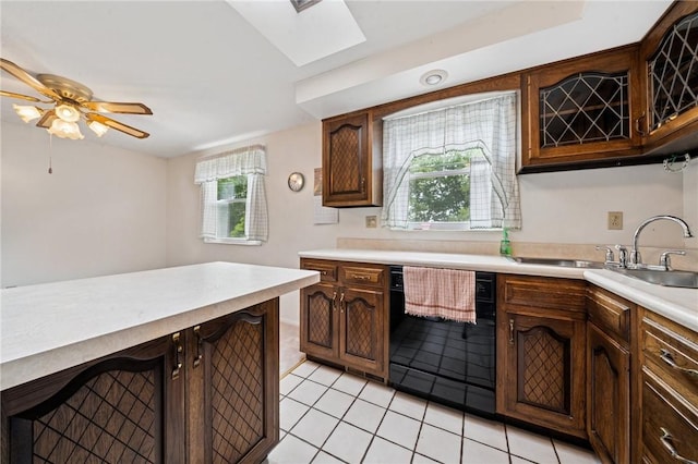 2154 Lancelot Dr, North Huntingdon, PA 15642 - kitchen featuring dishwasher, a sink, light countertops, light tile patterned flooring, and a skylight