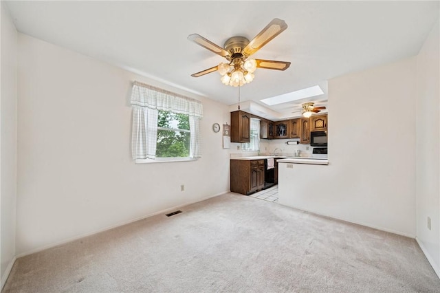 2154 Lancelot Dr, North Huntingdon, PA 15642 - kitchen featuring black appliances, ceiling fan, light colored carpet, a skylight, and light countertops