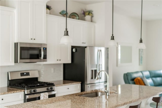 1001 Mohawk Ln, Marshall, PA 16046 - kitchen featuring appliances with stainless steel finishes, a sink, a breakfast bar area, white cabinetry, and light stone countertops