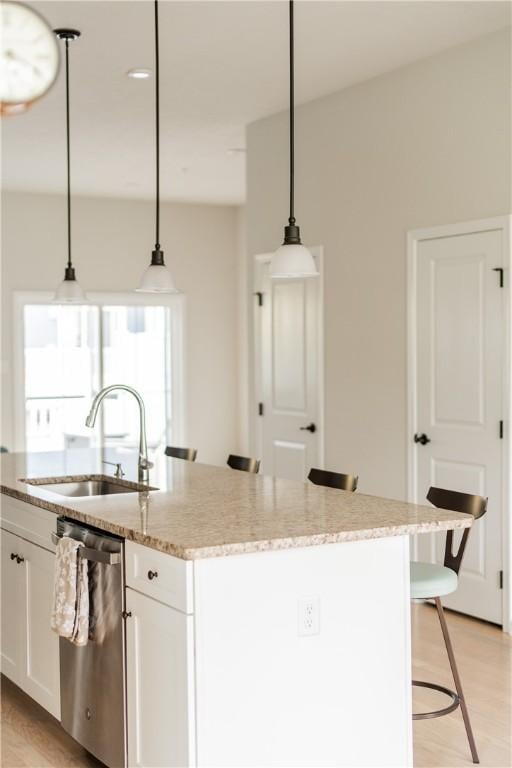 1001 Mohawk Ln, Marshall, PA 16046 - kitchen featuring stainless steel dishwasher, a sink, a center island with sink, white cabinets, and light wood finished floors